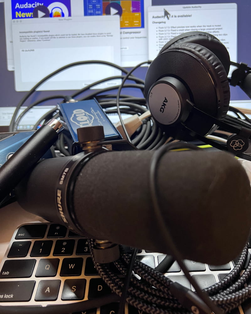 Messy home voiceover setup with microphone, audio interface, headphones, and laptop for at‑home recording consultation at L.A. Voiceover.